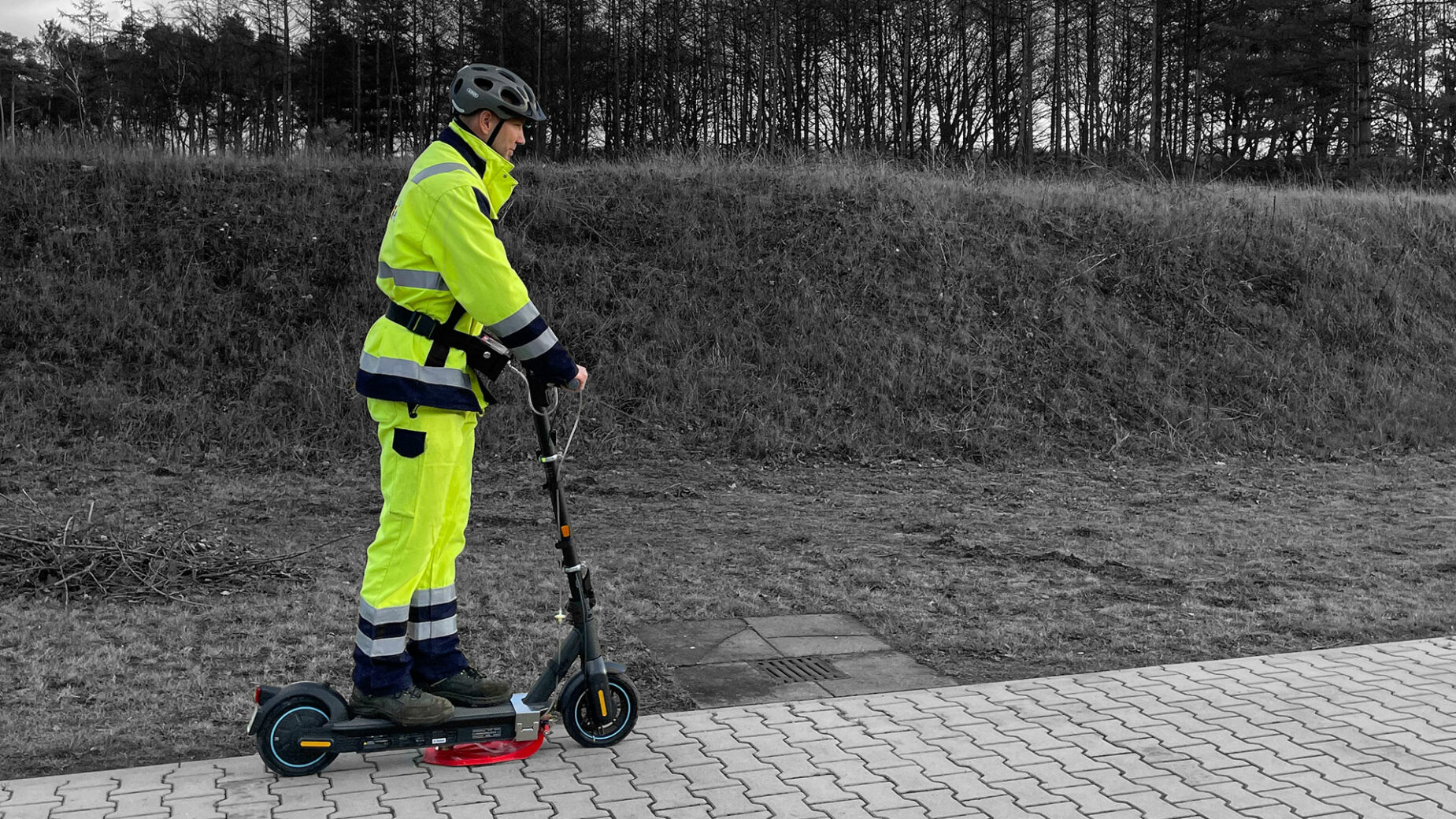 operario conduciendo un patinete eléctrico por la acera para detectar fugas de gas